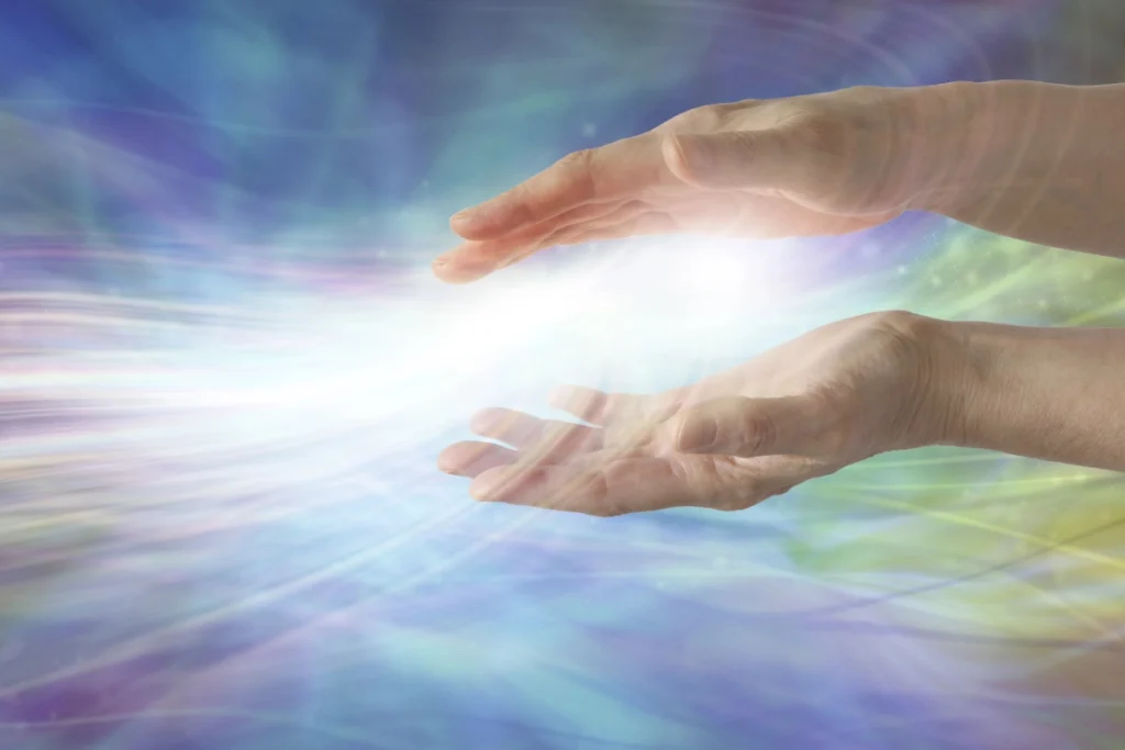 Hands channeling healing energy with glowing light and colorful waves representing different types of energy healing modalities.